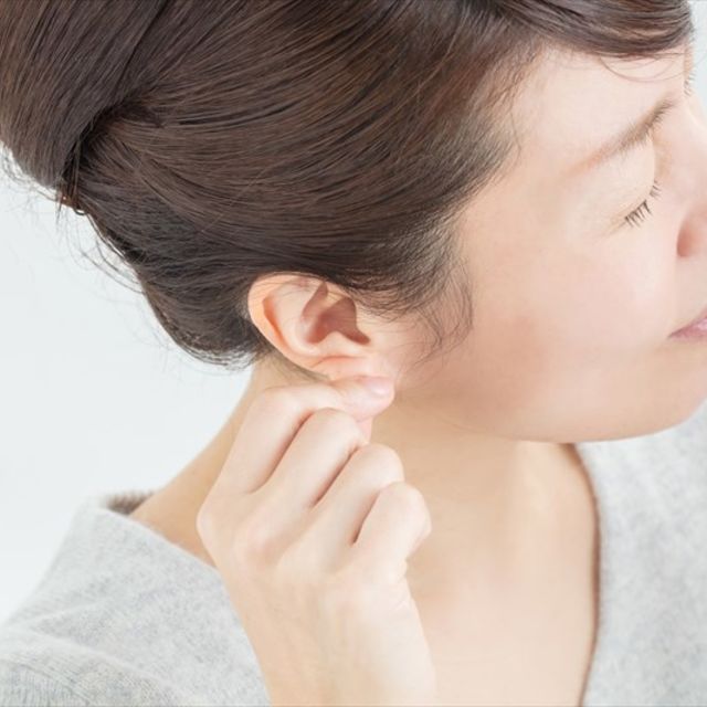女性が耳を触っている